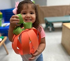 child with pumpkin