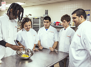 Culinary Arts students around chef's table