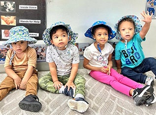 group of kids sitting on classroom floor