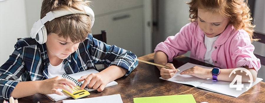 young boy andcyoung girl studying side by side at desk