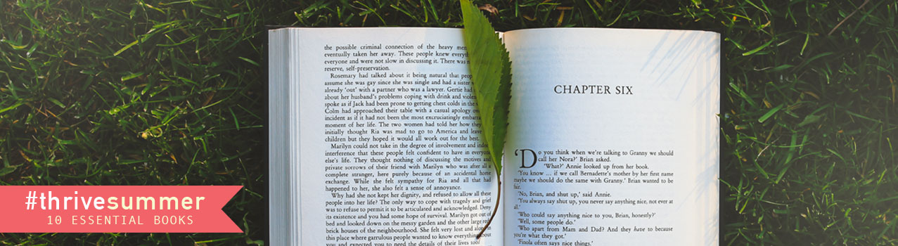 an open book on the grass, #thrivesummer in white text over it 