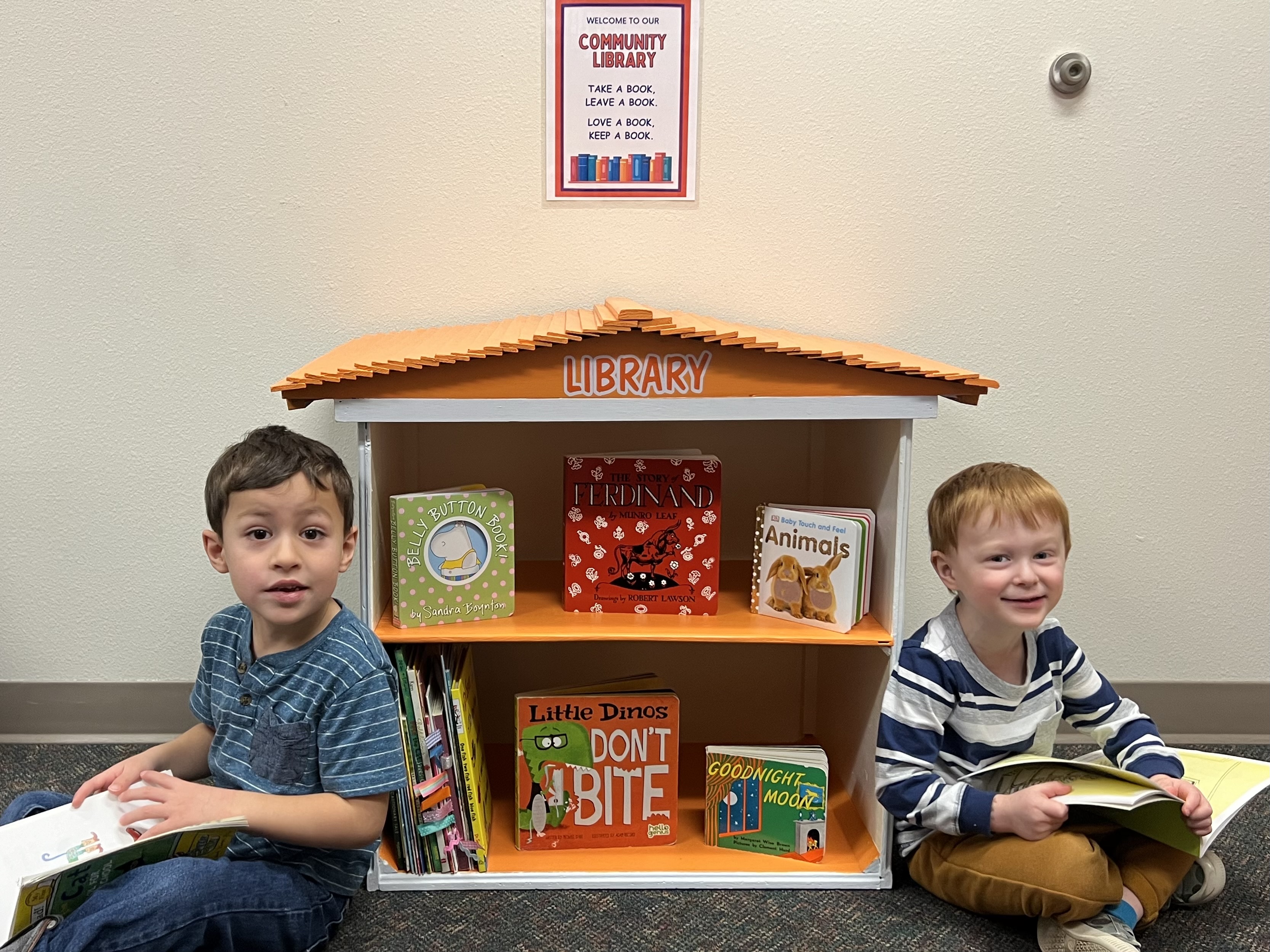 Two children reading books at the Community Library